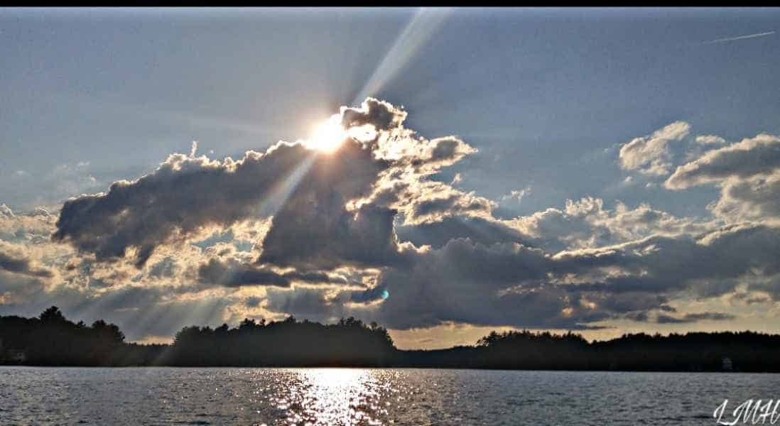 Sunny Sky Peaking Through Clouds Over The Lake in Barrington, New Hampshire